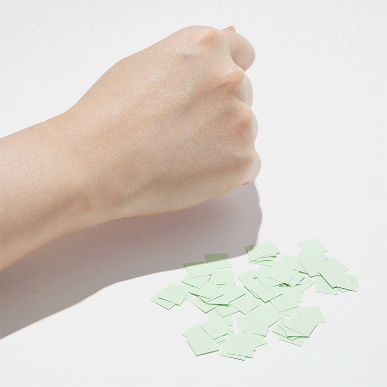 제품을 손등에 바르고 종이 조각들을 댄 후 뭍어나지 않는 사진